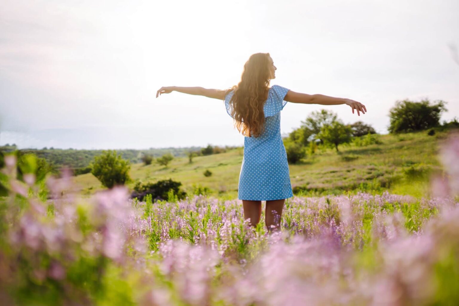Eine junge Frau in stylischem Sommerkleid die sich frei fühlt