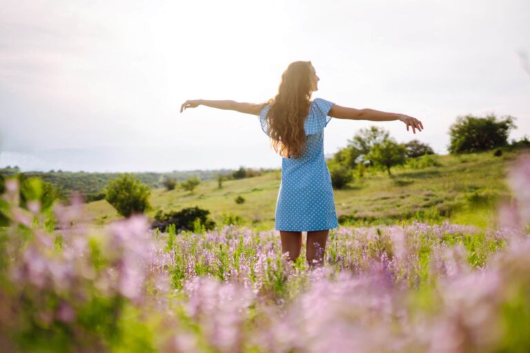 Eine junge Frau in stylischem Sommerkleid die sich frei fühlt